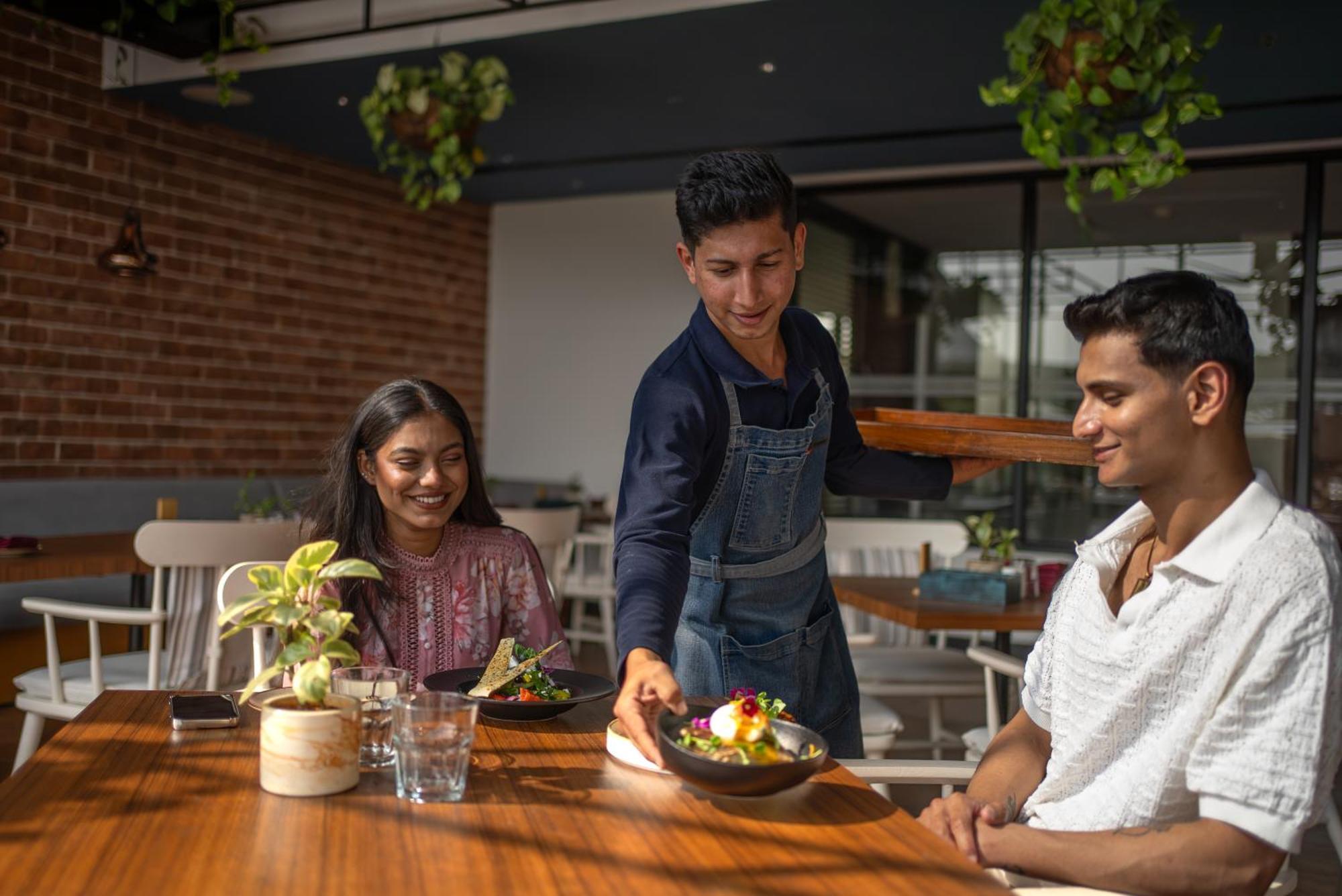 Hyatt Centric Mg Road Bangalore Exterior photo A waiter serving food to customers